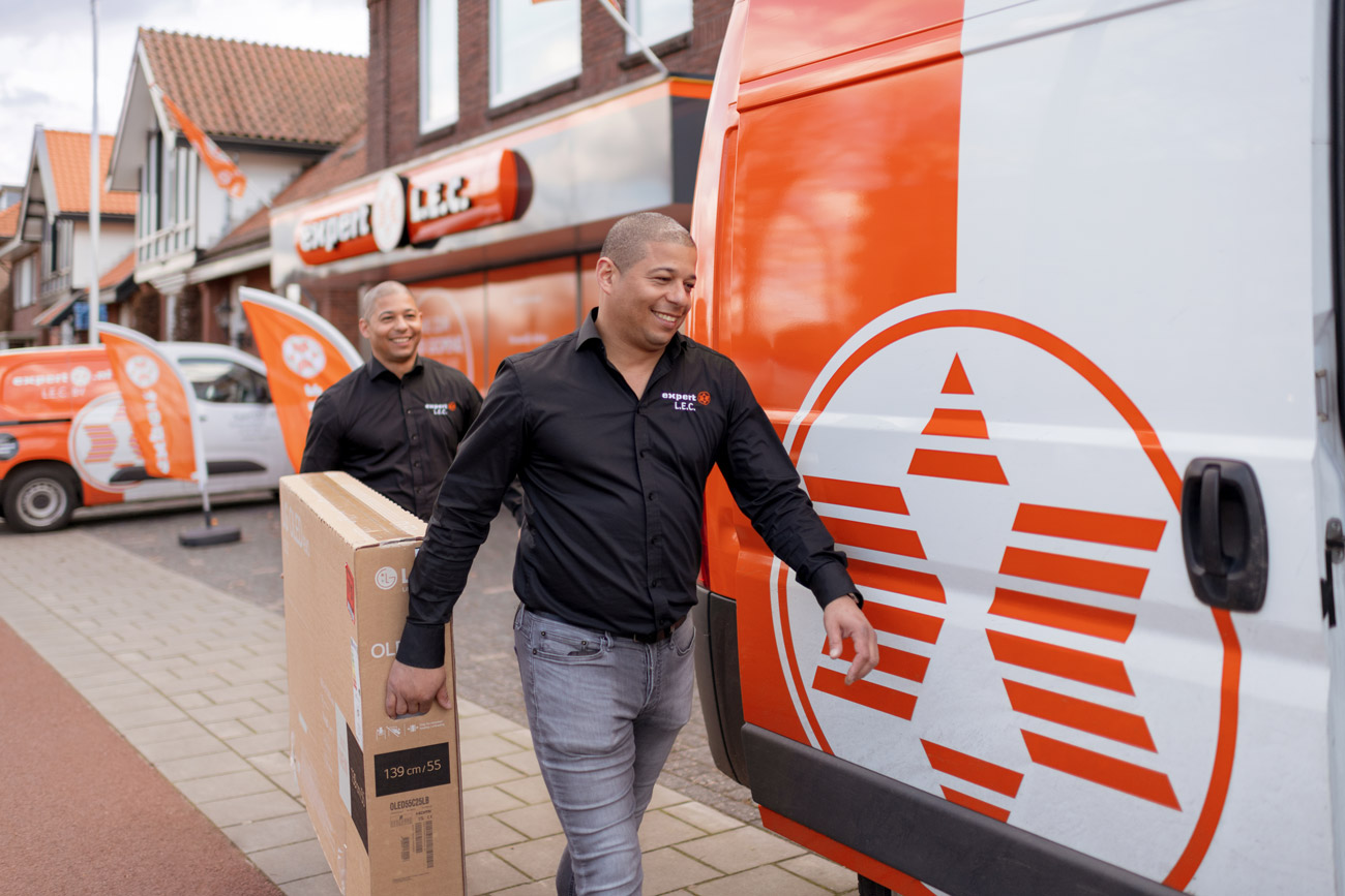 Expert ondernemers laden een tv scherm in de bus voor bezorging